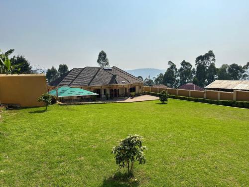 una casa con un césped verde delante de ella en Makanga Hill Suites, en Kabale