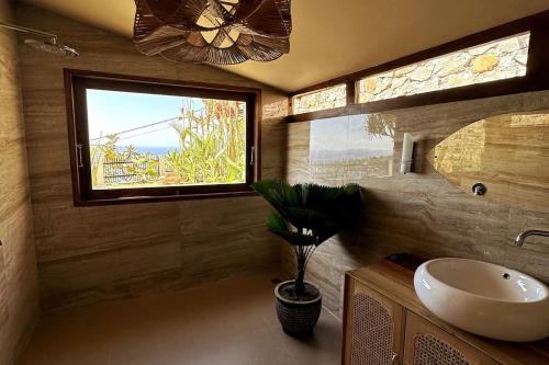 a bathroom with a sink and a window at Hillside Chalet with panoramic views in Ambat