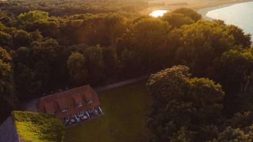 an aerial view of a house with trees and water at Gut Oehe in Maasholm