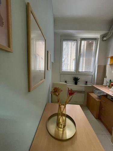 a vase with flowers on a table in a kitchen at Happy place in Sarajevo