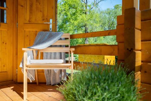 a wooden chair sitting on a porch next to a fence at srub slovenice in Dolní Slověnice