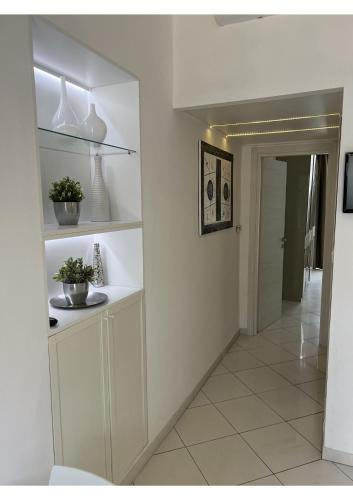 a hallway with white walls and a white tile floor at Lingotto35 in Turin