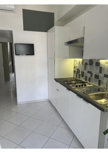 a white kitchen with a sink and a stove at Lingotto35 in Turin