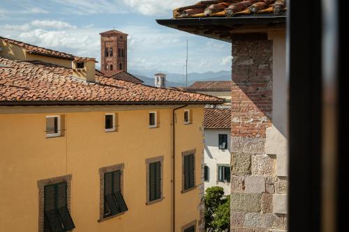 a view from a window of buildings with a clock tower at Grand Universe La Residenza in Lucca
