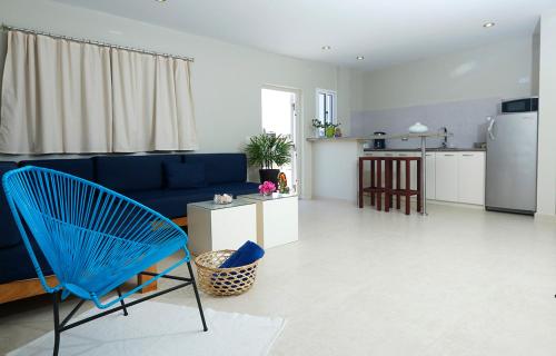 ein Wohnzimmer mit einem blauen Sofa und einer Küche in der Unterkunft Posada Buena Vista Beach Club in El Yaque