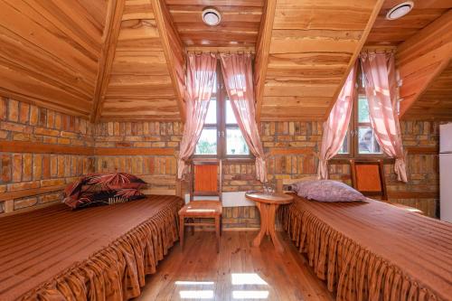 - 2 lits dans une chambre dotée de plafonds en bois et de fenêtres dans l'établissement Meškiai, à Meškiai
