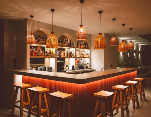 a bar with a row of stools and lights at Carruba Boutique Hotel in Kaş