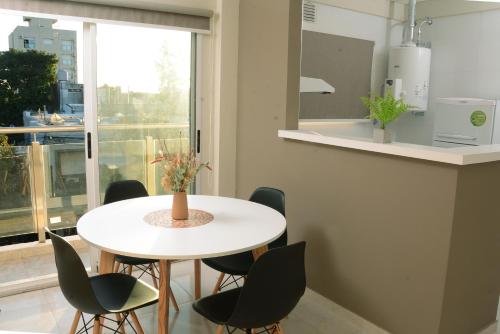 una mesa blanca y sillas en una cocina con ventana en Villa Apart Center en Villa Constitución