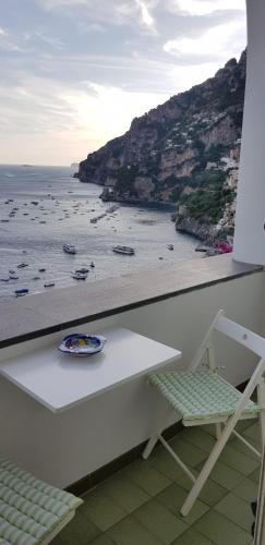 a table and a chair with a view of the ocean at Relais Zio Vincenzo Casa Positano in Positano