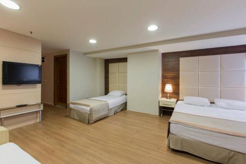 um quarto de hotel com duas camas e uma televisão de ecrã plano em Derpa Hotel em Istambul
