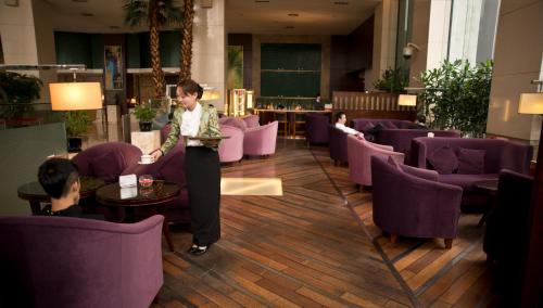 a woman standing in a room with purple chairs at Overseas Chinese Hotel Wenzhou in Wenzhou