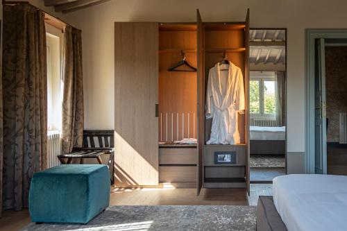 a bedroom with a closet with a robe on it at Grand Universe La Residenza in Lucca
