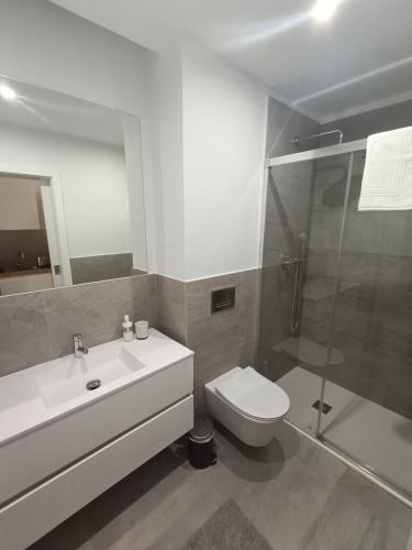 a bathroom with a toilet sink and a shower at Casa Saudade in Charneca