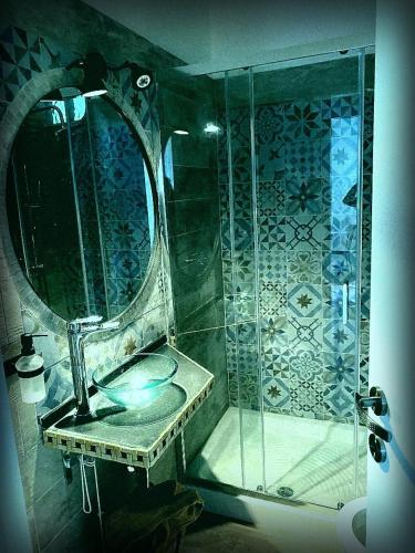 a bathroom with a shower with a sink and a mirror at Laviniahouse Nettuno in Nettuno
