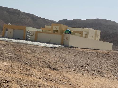 a house in the middle of a desert with a hill at شاليه درة رأس الجنز Dorrat Ras Al Jinz Chalet in Junayz al Janūbī