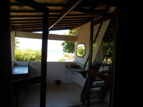 a room with bunk beds and a view of the ocean at Pousada Casa Canto das Águas in Icaraí