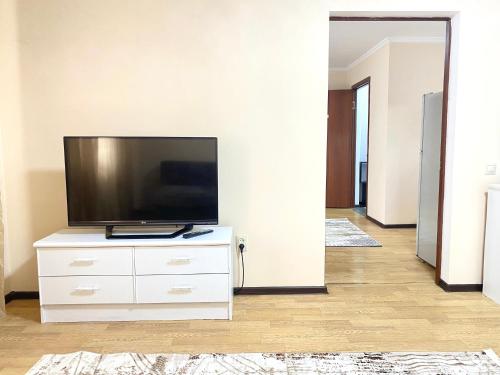 een woonkamer met een flatscreen-tv op een dressoir bij Town House, Метро Райымбек in Alma-Ata