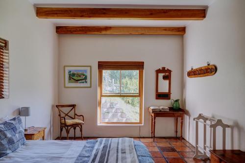 a bedroom with a bed and a window at Somerset Gift Getaway Farm in Swellendam