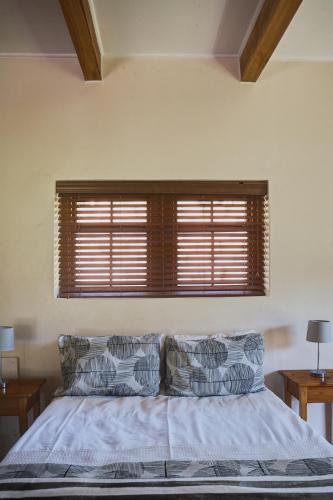 a bedroom with a bed with two pillows and a window at Somerset Gift Getaway Farm in Swellendam