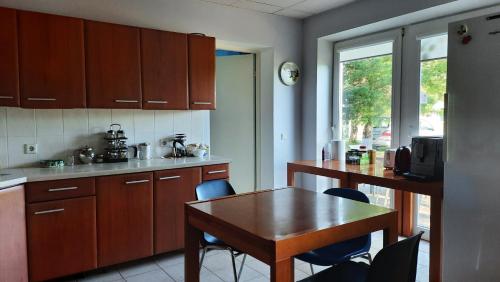 una cucina con un tavolo e sedie in legno e un tavolo e un piano del tavolo di Willipu Guesthouse ad Alatskivi