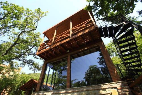 a tree house with a roof on top of a wall at Villa Vejini cabin in Mamkoda