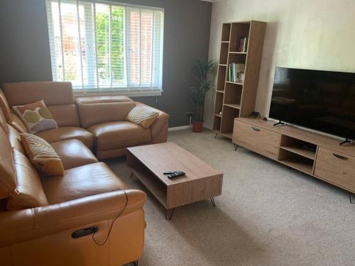 a living room with a couch and a flat screen tv at Cosy one bed flat free parking in Send