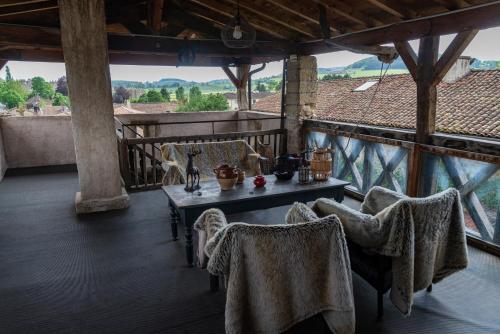 a room with a table and chairs on a balcony at Art'Hotel & SPA Le Potin Gourmand in Cluny