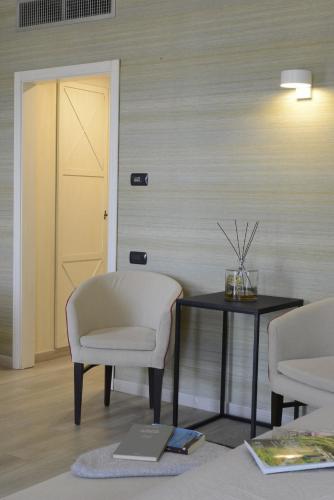a room with two chairs and a table and a door at Hotel Villa Cappugi in Pistoia