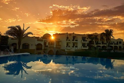 a sunset over a villa with a swimming pool at Dawar El Omda (Adults Only) in Hurghada