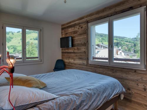 una camera da letto con una parete in legno e un letto con finestre di Appartement Megève, 4 pièces, 7 personnes - FR-1-453-235 a Megève