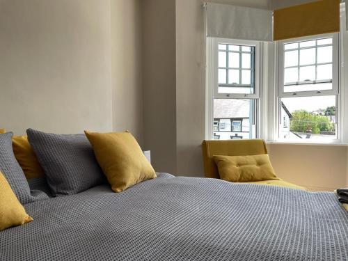 a bedroom with a bed and two windows at Northampton House in Llanwrtyd Wells