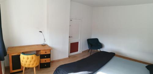 Schlafzimmer mit einem Bett, einem Schreibtisch und einem Stuhl in der Unterkunft Chambre cosy in Saint-Nicolas