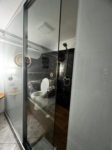 a bathroom with a toilet and a glass shower at Himalayas in Gjirokastër