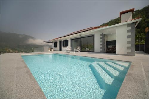 a swimming pool in front of a house at Casa Avô da Pedra, By OP in São Vicente