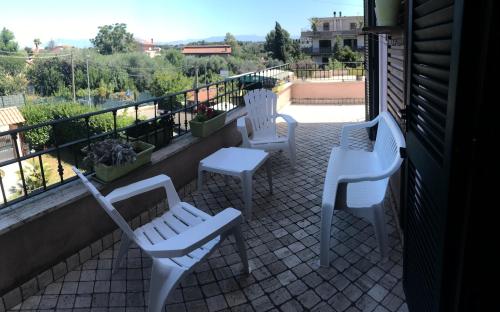 3 chaises et tables blanches sur un balcon dans l'établissement Casa Morena near Anagnina metro, à Rome