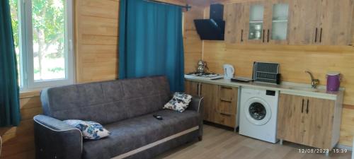 a living room with a couch and a washing machine at Teo Hotel in Cıralı