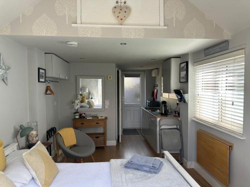 a bedroom with a bed and a desk and a kitchen at The Annexe in Waltham