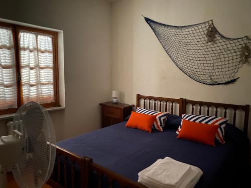 a bedroom with a bed with orange pillows and a net at Casa Trecci in Albinia