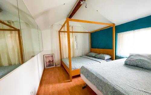 1 Schlafzimmer mit 2 Betten und einem Fenster in der Unterkunft MISSYT DUPLEX COLOMBES PROCHE PARIS ET LA DÉFENSE in Colombes