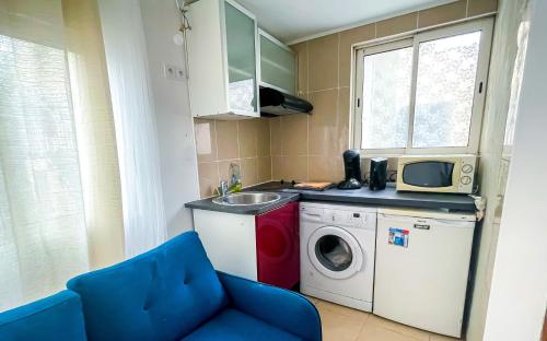 eine kleine Küche mit einer Waschmaschine und einem Waschbecken in der Unterkunft MISSYT DUPLEX COLOMBES PROCHE PARIS ET LA DÉFENSE in Colombes