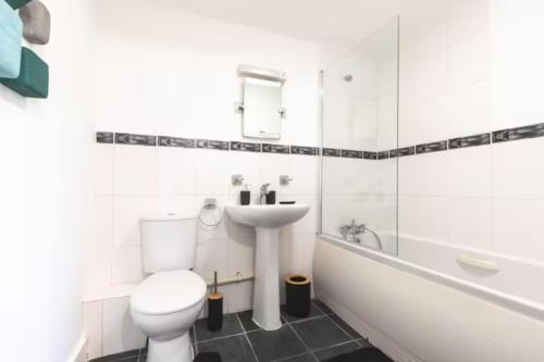 a white bathroom with a toilet and a sink at Chic 2-Bed Apartment in Southampton with Parking in Southampton