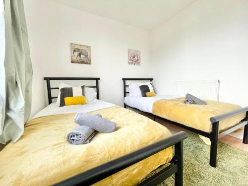 ein Schlafzimmer mit 2 Betten und Handtüchern darauf in der Unterkunft Chic 2-Bed Apartment in Southampton with Parking in Southampton