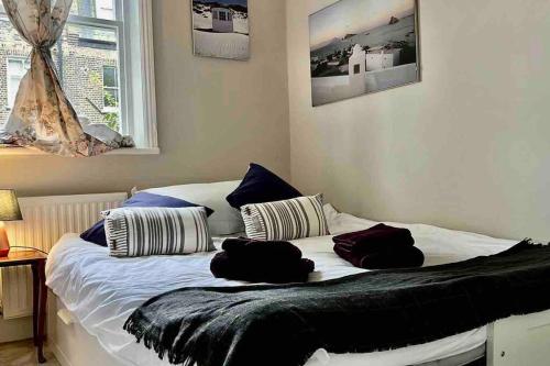 - un lit avec 2 oreillers dans une chambre dans l'établissement Wonderful apartment in Earl’s Court, à Londres