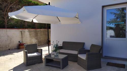 een patio met 2 stoelen en een parasol bij Affittacamere Sole e Luna in Vatolla