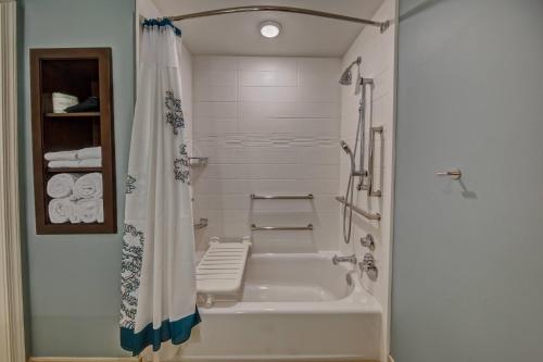 a white bathroom with a tub and a shower curtain at Residence Inn Fort Lauderdale Pompano Beach Central in Pompano Beach