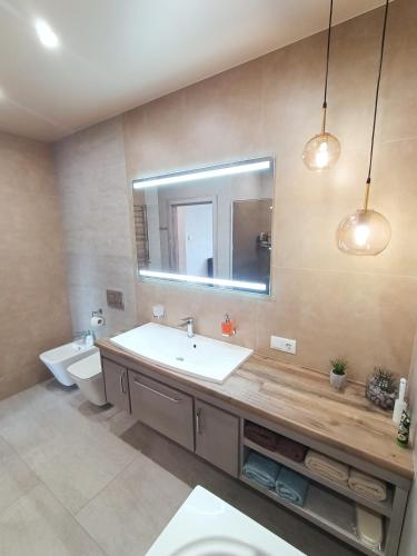 uma casa de banho com um lavatório, um WC e um espelho. em 2к шикарний люкс! em Khmelʼnytsʼkyy