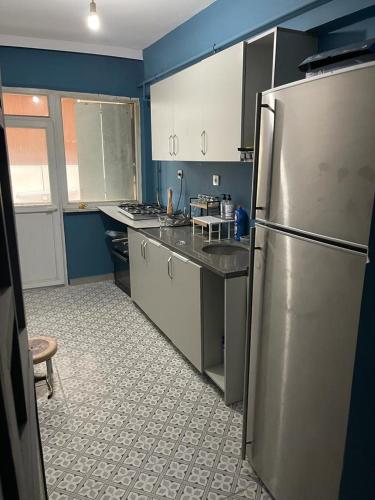 eine Küche mit einem Kühlschrank aus Edelstahl und blauen Wänden in der Unterkunft Deluxe Two bedroom apartment in nışantaşı in Istanbul