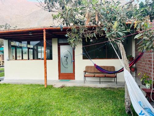 a house with a hammock in front of it at Casa camping san jerónimo in San Vicente de Cañete