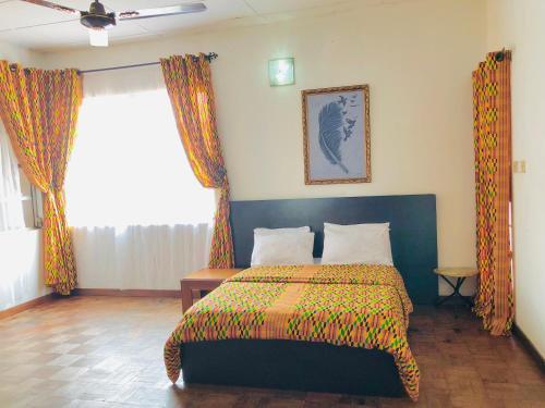 1 dormitorio con 1 cama con colcha colorida en GRACE LODGE ONITSHA, en Onitsha