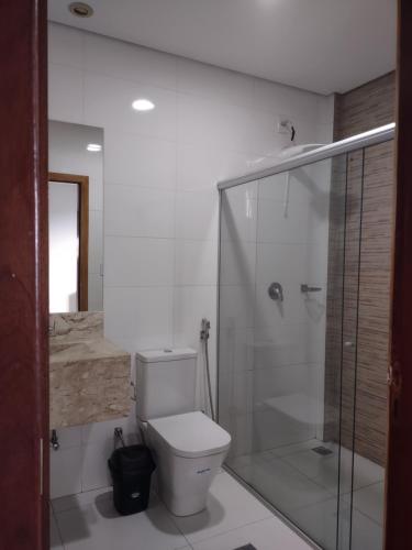 a bathroom with a toilet and a glass shower at Residencial Isaura in Rio Branco